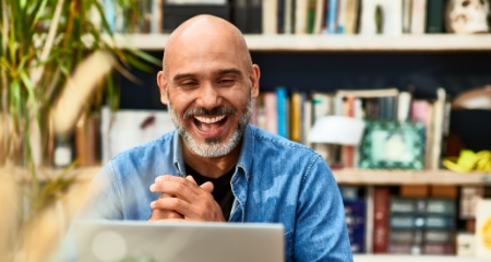 Man Smiling Behind Laptop